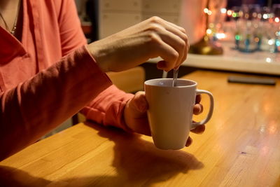 Man holding coffee cup on table