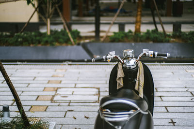 Motor scooter parked at cobbled street