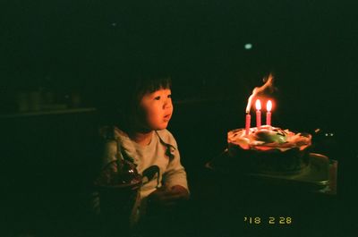 Lit candles in dark room