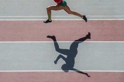 Low section of woman running on track