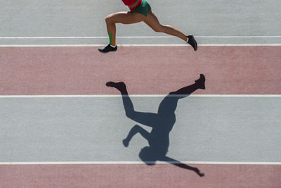 Low section of man running on zebra crossing