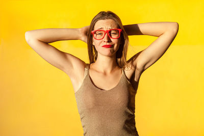 Portrait of beautiful young woman over yellow background