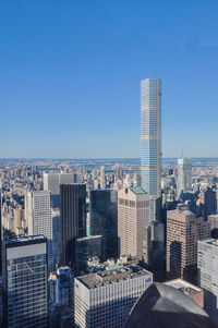 Modern buildings in city against clear blue sky