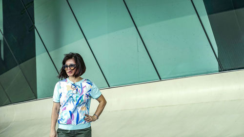 Woman standing before the green glasses building