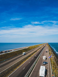 Aerial view of highway by sea against sky