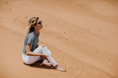 Young woman sitting at desert