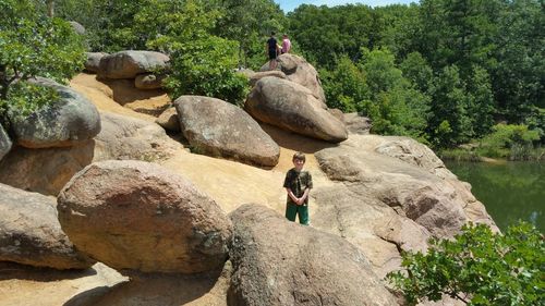 Rear view of men on rock against trees