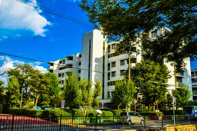 Low angle view of trees and buildings against sky