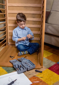 High angle view of boy sitting at home