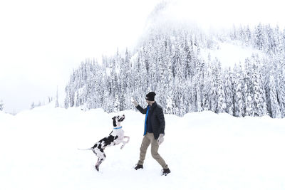 Full length of man playing on snow against sky