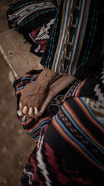 Cropped image of couple holding hands below blanket