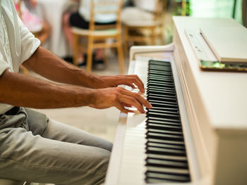 Midsection of man playing piano