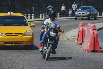 Man riding motorcycle on street in city