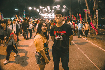 People standing on street in city at night