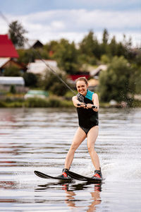 Full length of waterskiing in lake