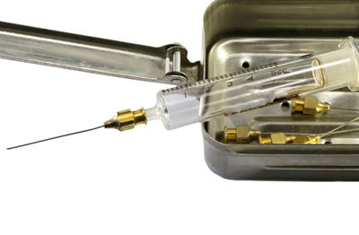 Close-up of syringe over white background