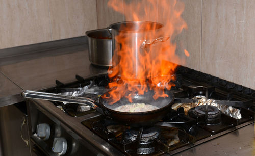 Close-up of fire in cooking pan on stove at home