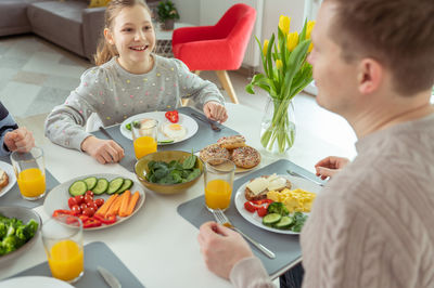 Smiling woman having food at home