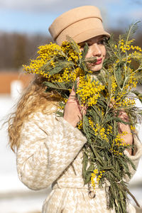 A  woman with a yellow acacia flowers. the concept of the spring - march 8, easter, women's day