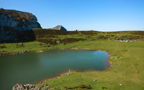 Scenic view of lake and mountains against clear blue sky