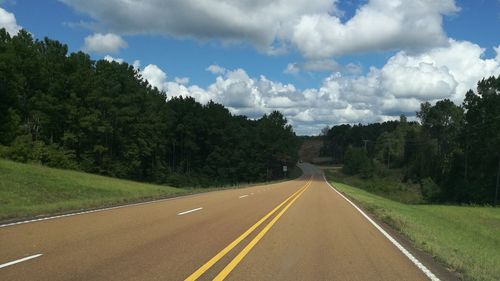 Road amidst trees against sky