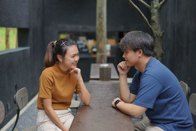 Side view of a smiling young woman sitting outdoors