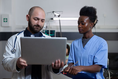 Doctor and nurse looking at laptop in clinic