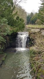 Scenic view of waterfall against sky