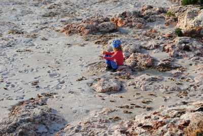 High angle view of girl sitting at beach