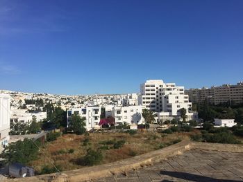 Buildings in city against clear blue sky