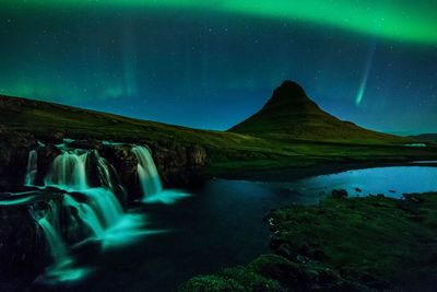 Scenic view of waterfall against sky at night