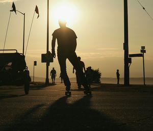 Silhouette of woman jumping at sunset