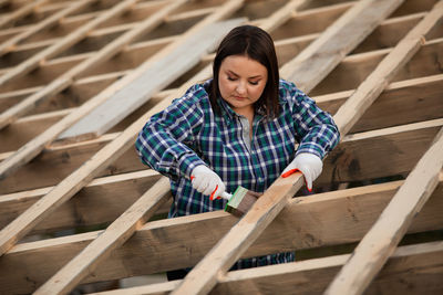 Full length of woman working on wooden plank