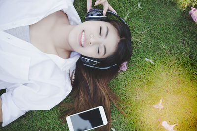 Portrait of woman lying on grassy field