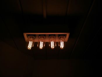 Low angle view of illuminated lamp in darkroom