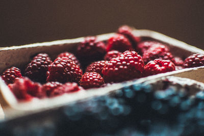 Blackberries and raspberries in containers on table