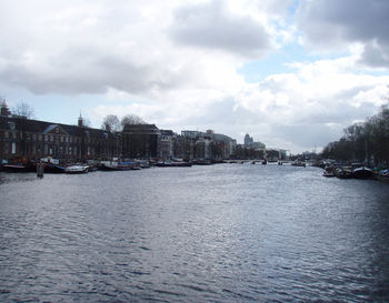 River in city against cloudy sky