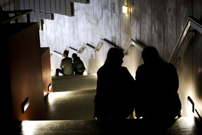 Silhouette people in illuminated room