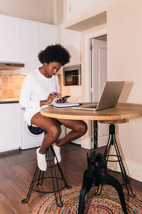 Man using phone while sitting on table at home