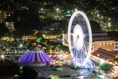 Panoramic view of illuminated ferris wheel at night