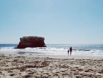 Man on beach against clear sky