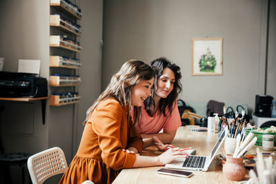 Two attractive young female employees discussing their business in workshop