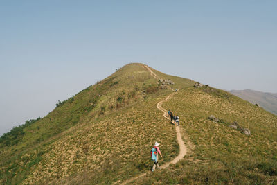 People on mountain against clear sky