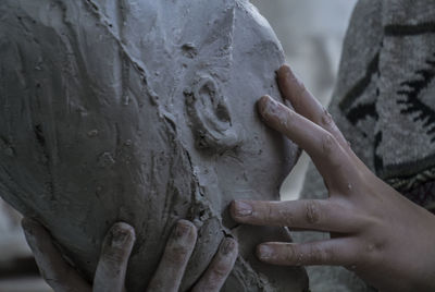 Close-up of human hand holding statue