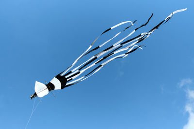Low angle view of bird flying against clear blue sky
