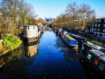 Boats moored in canal against sky