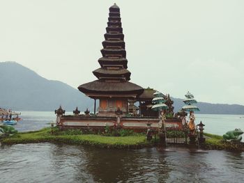 Temple by building against sky