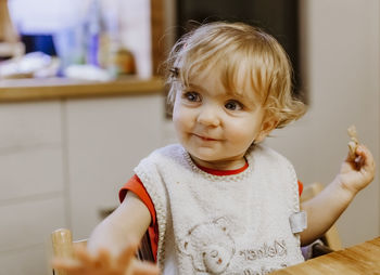Close-up of baby girl eating food at table