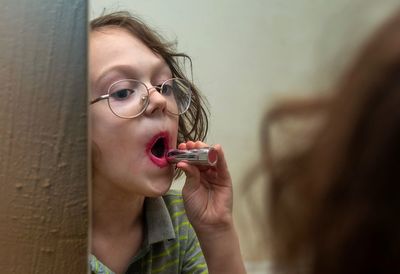 Boy with messy lipstick looking in mirror