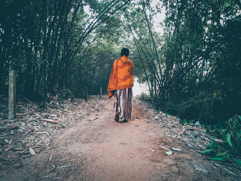 Rear view of man cycling in forest